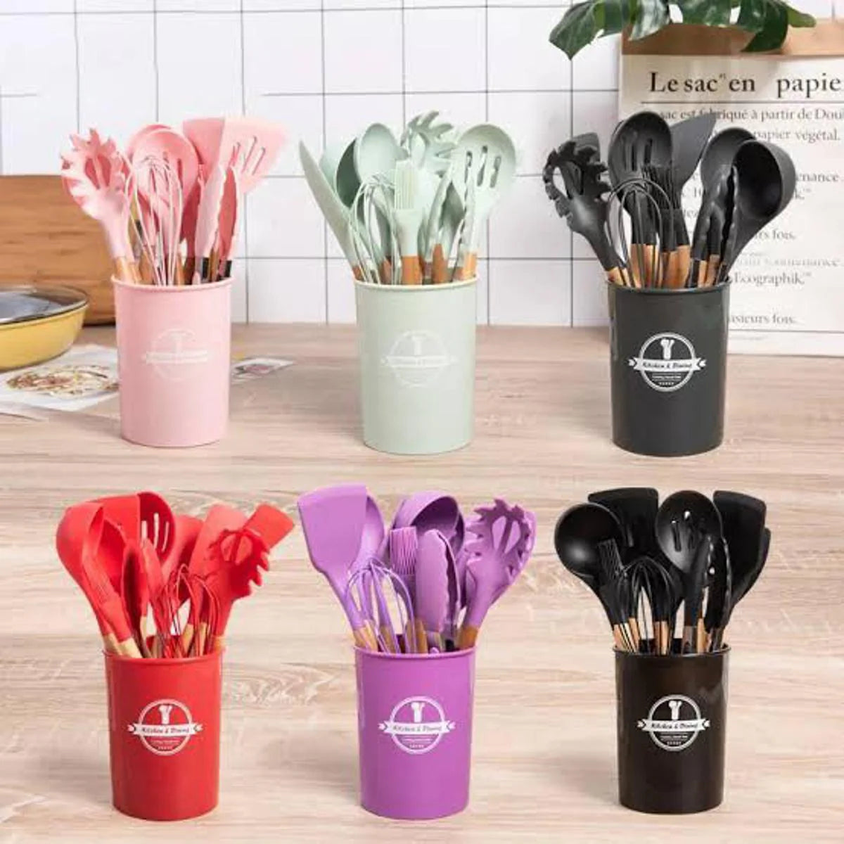 Set of colorful kitchen utensils in holders on a wooden surface.