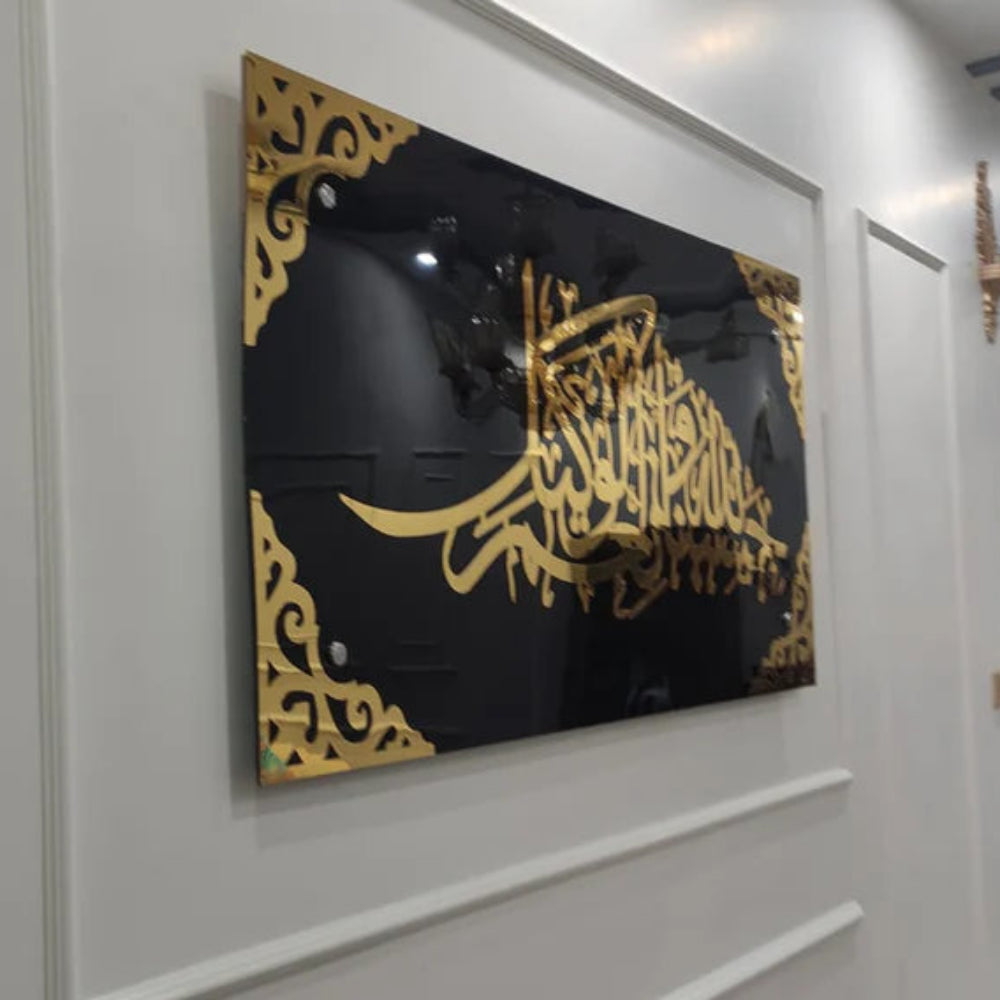Decorative wall art with gold calligraphy on a black background in a modern interior setting.