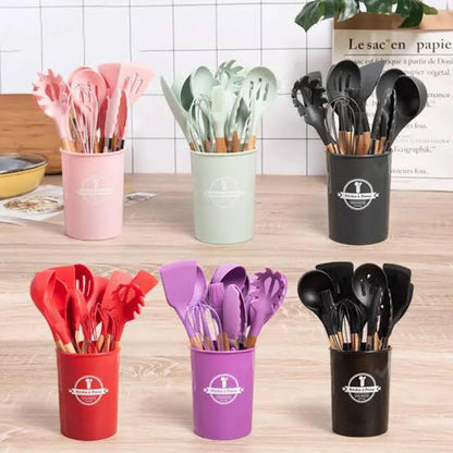 Set of colorful kitchen utensils in holders on a wooden surface.