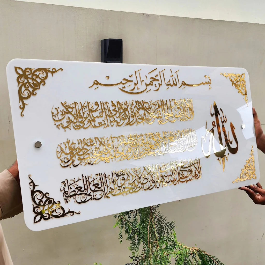 Decorative sign with Arabic calligraphy and gold accents held by a person.