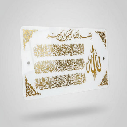Decorative sign with Arabic calligraphy and gold designs held by a person.