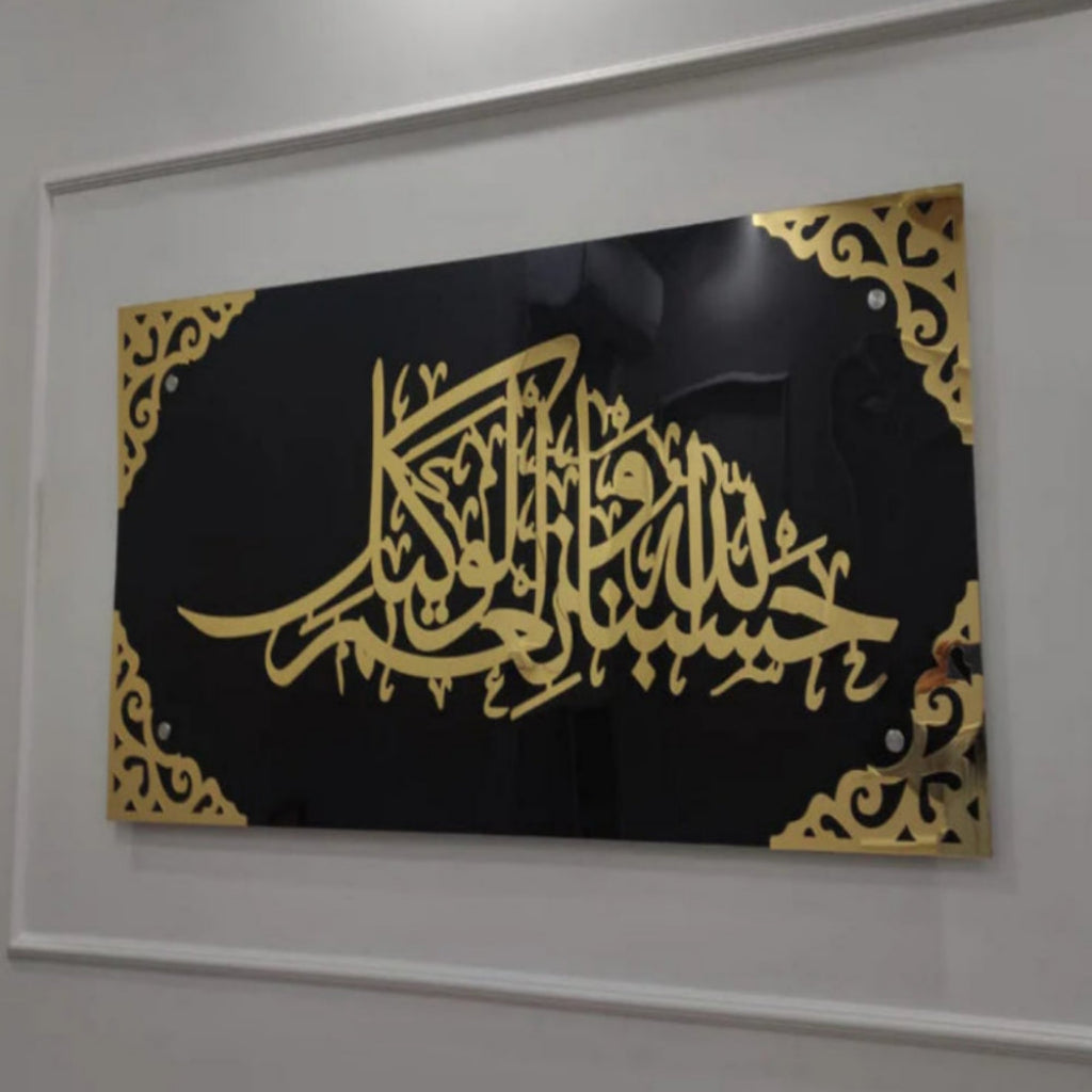 Framed artwork with gold calligraphy on a black background, mounted on a white wall.