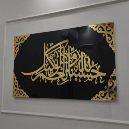 Framed artwork with gold calligraphy on a black background, mounted on a white wall.