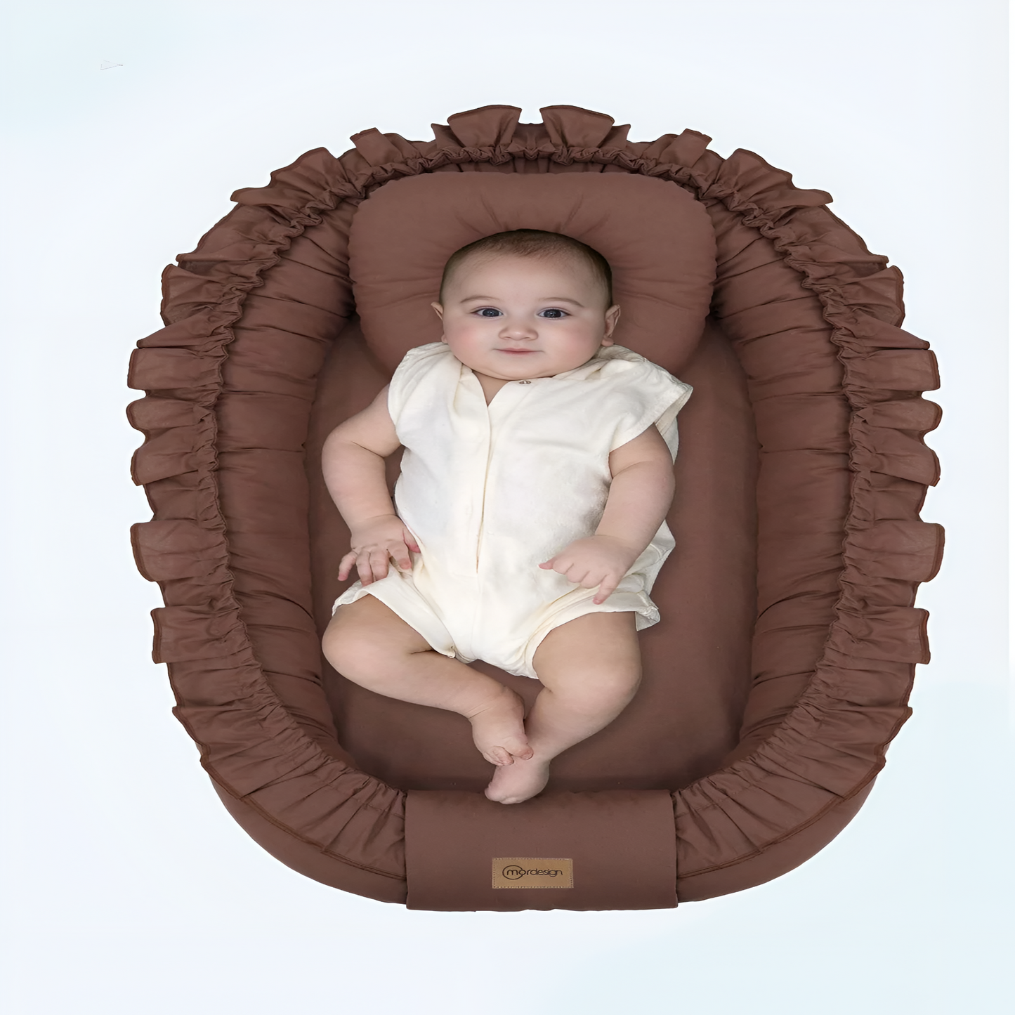 Baby in a brown oval bassinet with a plain background
