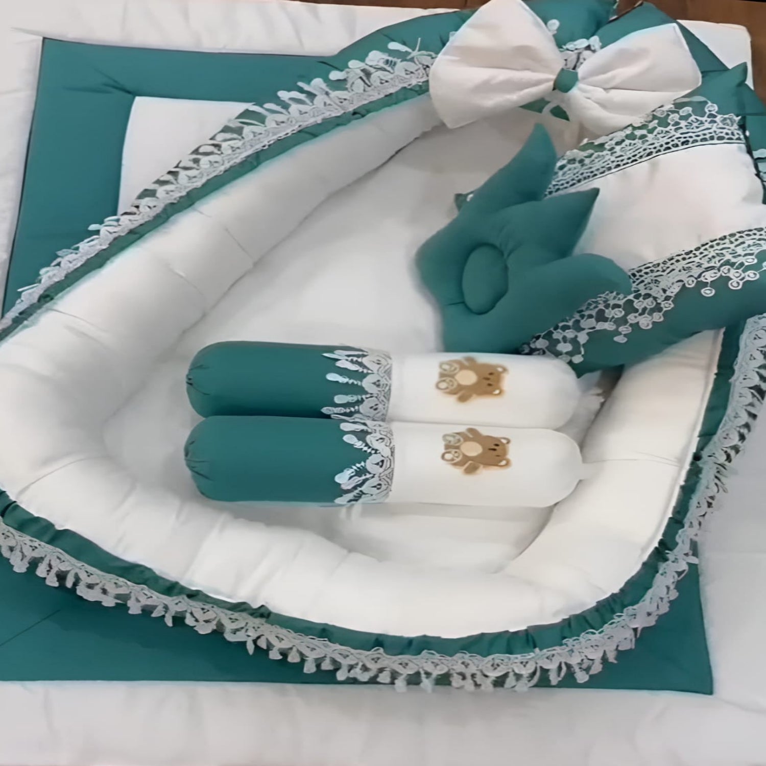 Teal and white baby crib set with decorative elements on a white background
