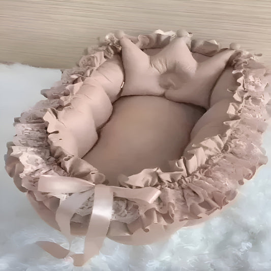 Pink baby crib with ruffled details on a white background