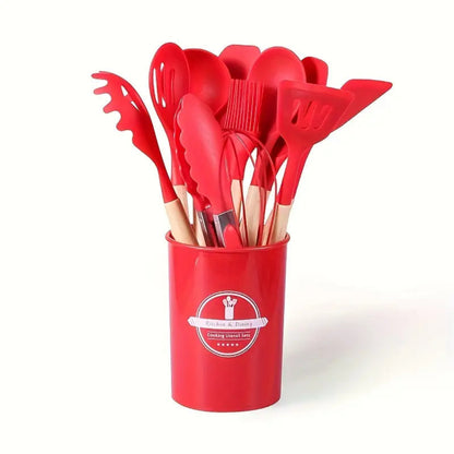 Set of red kitchen utensils in a red holder on a white background