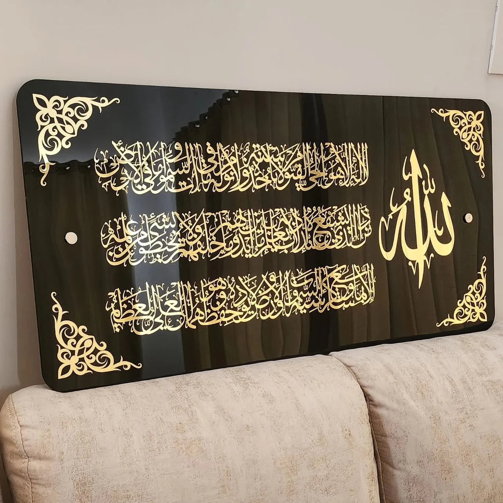 Decorative headboard with gold Arabic calligraphy on a black background, placed on a beige sofa.