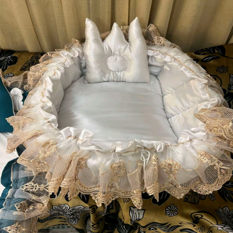 Decorative baby crib with lace and ruffles on a patterned rug.