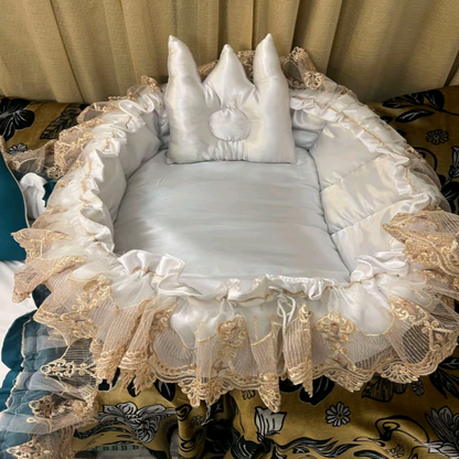 Decorative baby crib with lace and ruffles on a patterned rug.